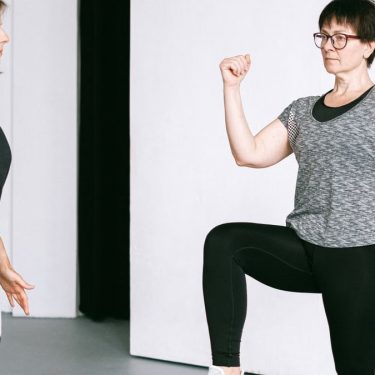 Two women working out together, demonstrating fitness exercises on a white background.